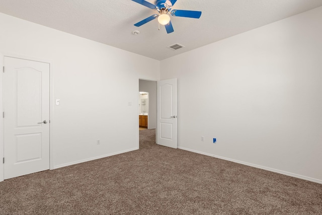 carpeted spare room featuring ceiling fan and a textured ceiling