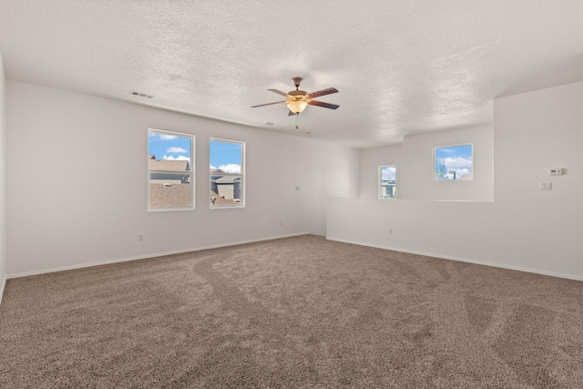 empty room featuring carpet flooring, a wealth of natural light, and ceiling fan