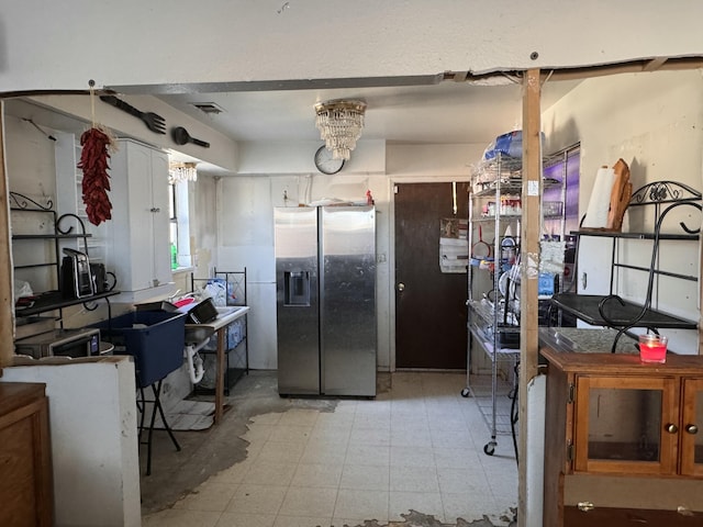 kitchen featuring white cabinetry and stainless steel fridge with ice dispenser