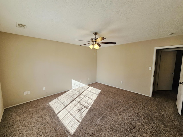 carpeted empty room featuring ceiling fan and a textured ceiling