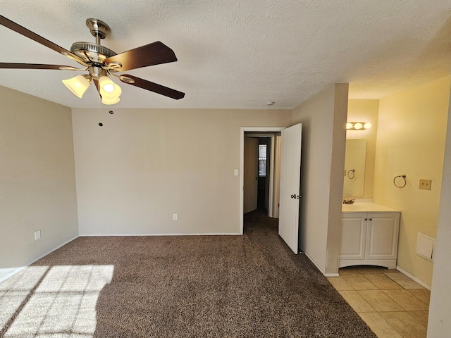 carpeted empty room with ceiling fan and a textured ceiling