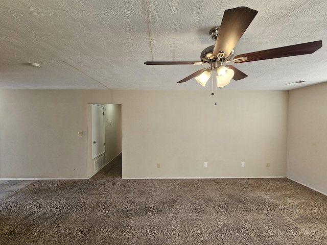 carpeted spare room featuring ceiling fan and a textured ceiling