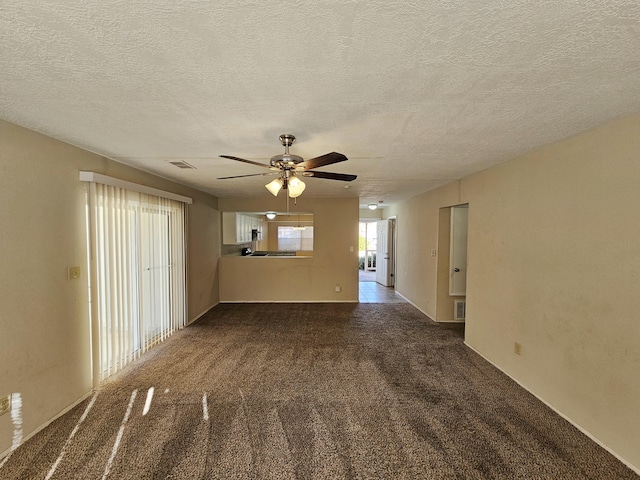 carpeted spare room with ceiling fan and a textured ceiling