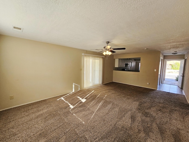 unfurnished room featuring carpet, ceiling fan, and a textured ceiling