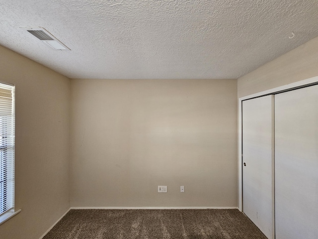 unfurnished bedroom featuring carpet and a textured ceiling