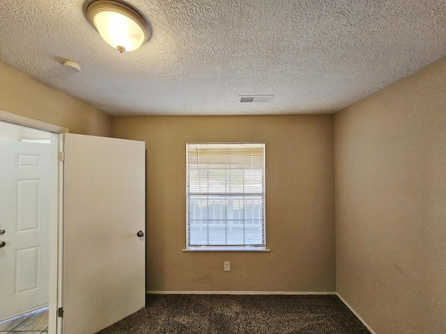 carpeted spare room featuring a textured ceiling