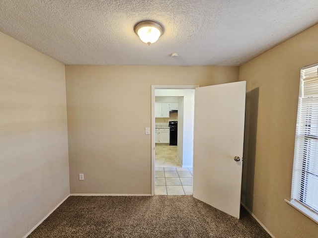 carpeted empty room with a textured ceiling