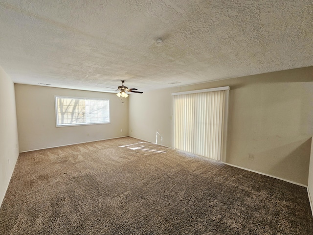 carpeted spare room featuring a textured ceiling and ceiling fan