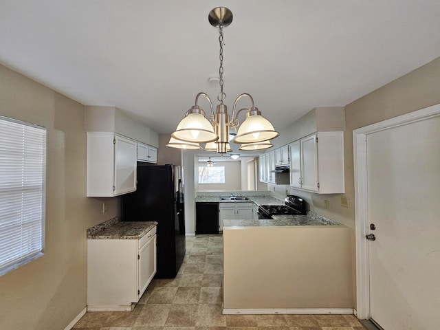 kitchen with black appliances, decorative light fixtures, white cabinets, and a chandelier