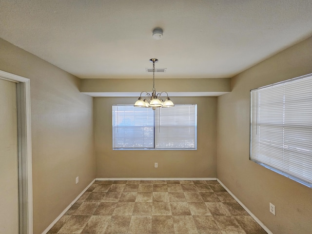 spare room featuring an inviting chandelier