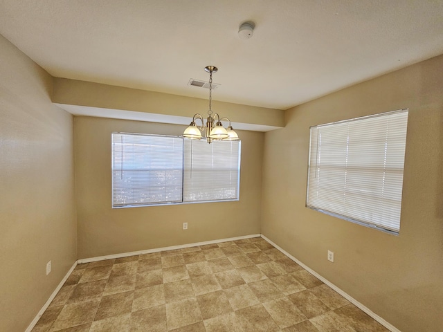 spare room with an inviting chandelier