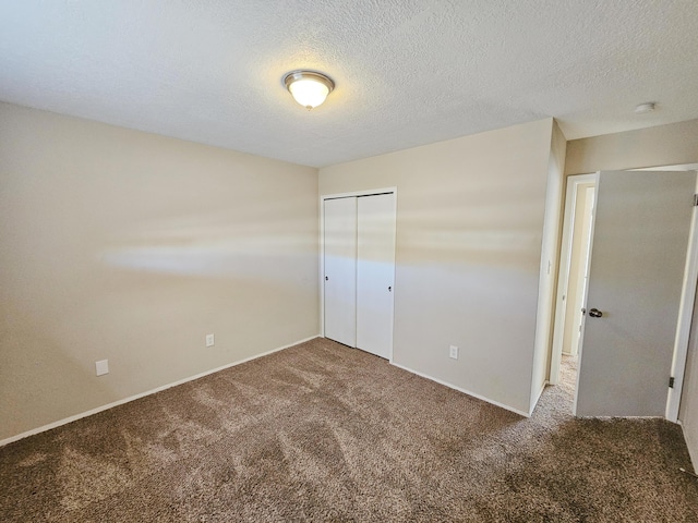 unfurnished bedroom featuring carpet flooring, a textured ceiling, and a closet