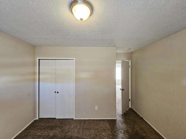 unfurnished bedroom featuring dark colored carpet and a closet