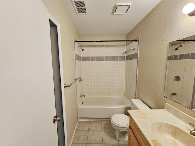 full bathroom featuring tile patterned floors, vanity, tiled shower / bath, and toilet