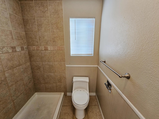 bathroom with toilet, tile patterned floors, and walk in shower