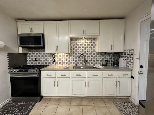 kitchen featuring backsplash, white cabinets, sink, and stainless steel appliances