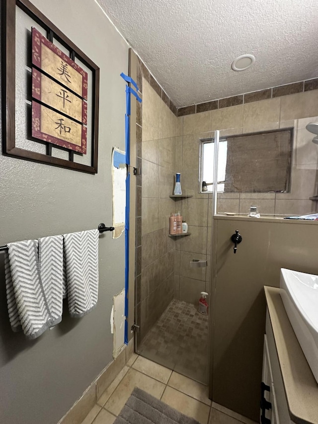 bathroom featuring a textured ceiling, tile patterned floors, and a shower with door