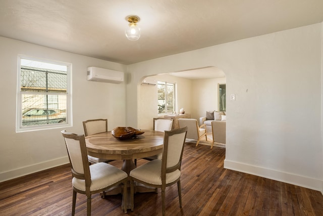 dining area featuring dark wood-type flooring and a wall unit AC