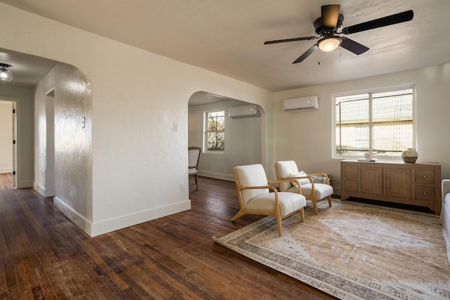 unfurnished room with a wall mounted AC, dark wood-type flooring, and ceiling fan