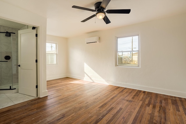 spare room with ceiling fan, light wood-type flooring, and an AC wall unit