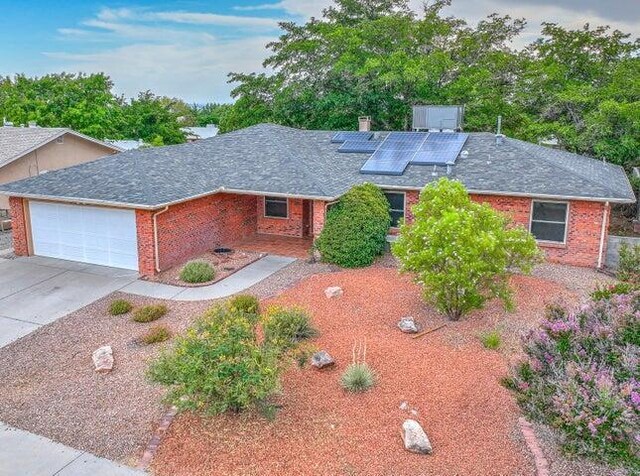 view of front of property featuring solar panels and a garage