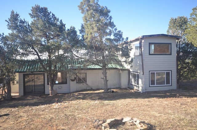 rear view of property featuring a lawn