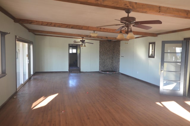 unfurnished room featuring ceiling fan, dark hardwood / wood-style flooring, beamed ceiling, and a healthy amount of sunlight
