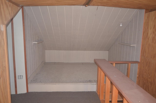 bonus room featuring wooden walls and vaulted ceiling