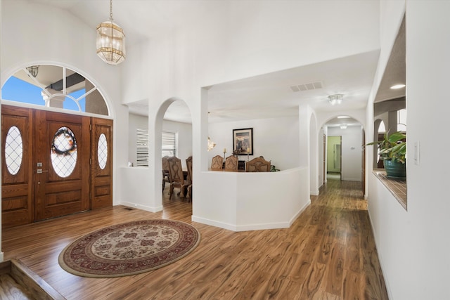 foyer featuring lofted ceiling, a notable chandelier, and hardwood / wood-style flooring