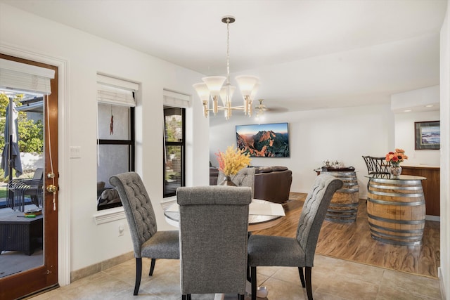 dining room with plenty of natural light, light tile patterned floors, and a chandelier