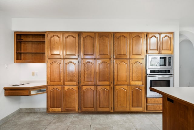 kitchen with light tile patterned flooring and appliances with stainless steel finishes