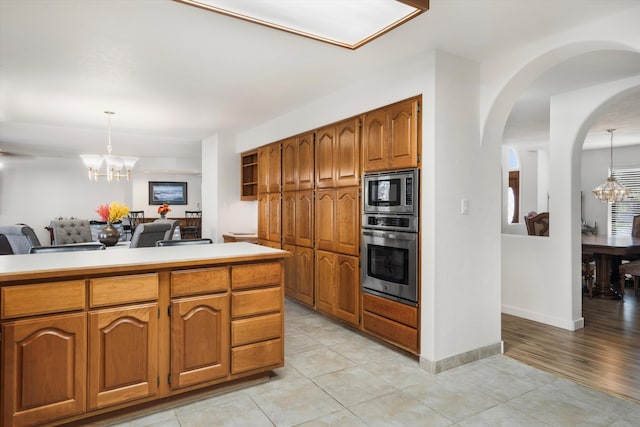 kitchen featuring appliances with stainless steel finishes, hanging light fixtures, and a notable chandelier