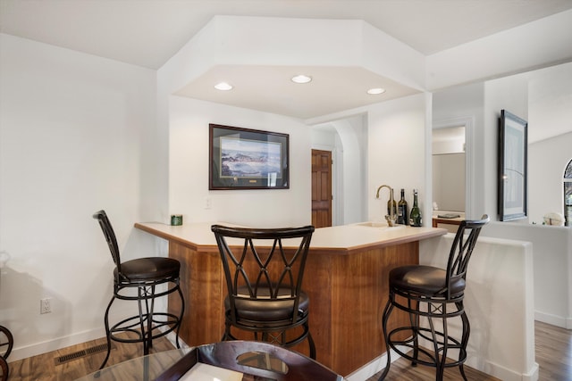 bar featuring dark hardwood / wood-style flooring and sink