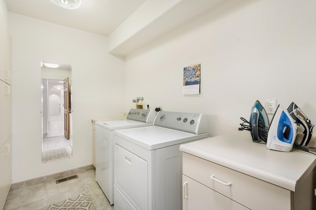 laundry room featuring cabinets, independent washer and dryer, and light tile patterned flooring