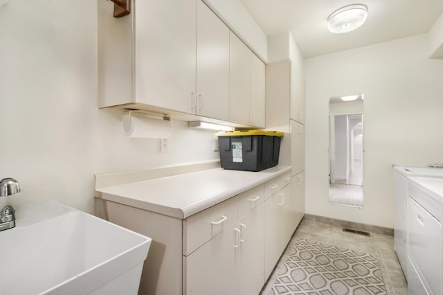 washroom featuring cabinets, independent washer and dryer, sink, and light tile patterned floors