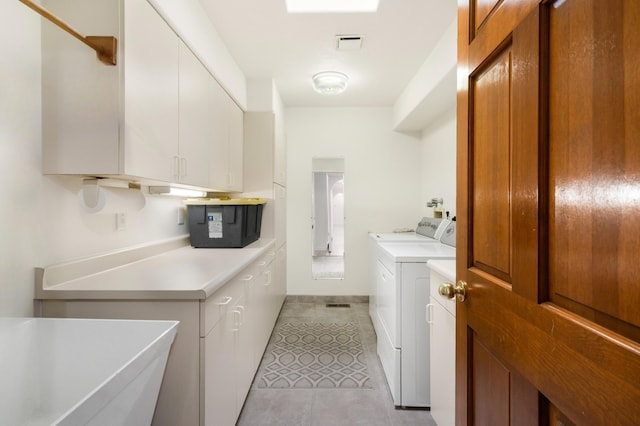 washroom featuring cabinets, light tile patterned flooring, and washing machine and dryer