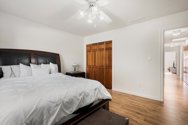 bedroom with ceiling fan, a closet, and hardwood / wood-style flooring