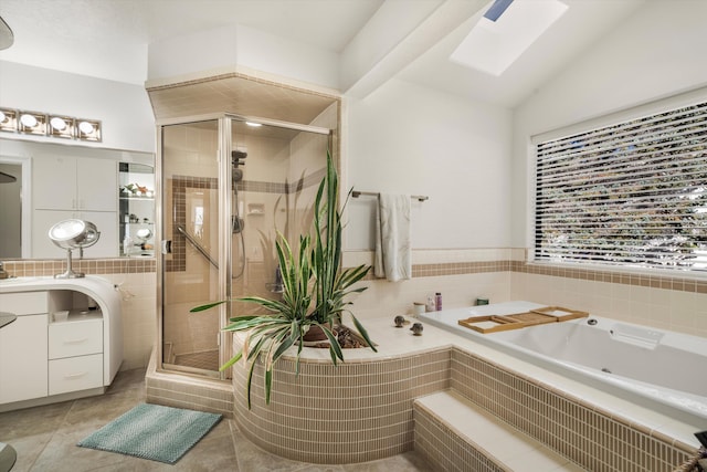 bathroom with vaulted ceiling with skylight, vanity, a shower with shower door, and tile patterned flooring