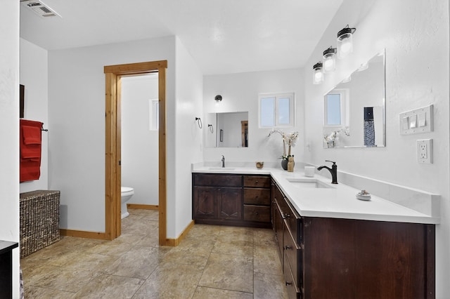 20 Orona Rd, Los Lunas, NM 87031 - full bath with double vanity, baseboards, toilet, and stone finish floors