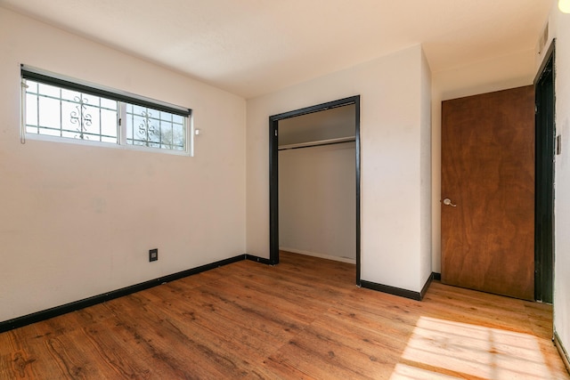 unfurnished bedroom featuring a closet and light wood-type flooring