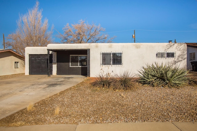 pueblo revival-style home featuring a garage