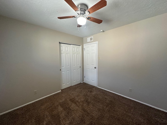 unfurnished bedroom featuring ceiling fan, a closet, carpet floors, and a textured ceiling