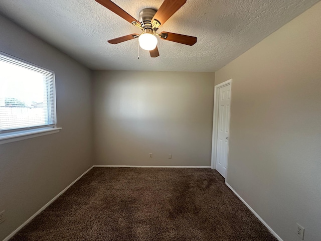 carpeted spare room with a textured ceiling and ceiling fan