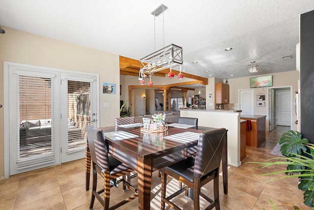 dining space featuring a wealth of natural light, a textured ceiling, ornate columns, and light tile patterned floors