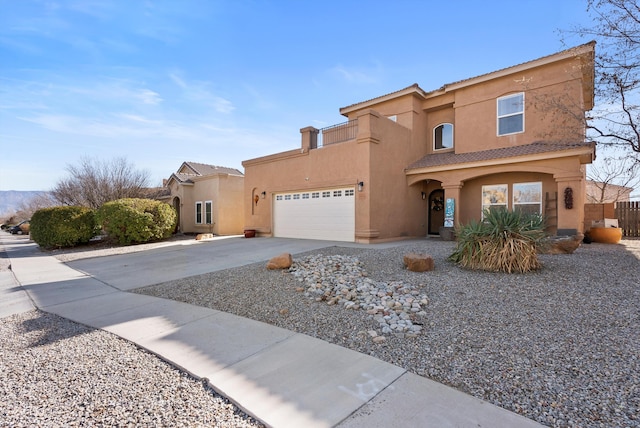 view of front facade with a garage, concrete driveway, a tiled roof, and stucco siding