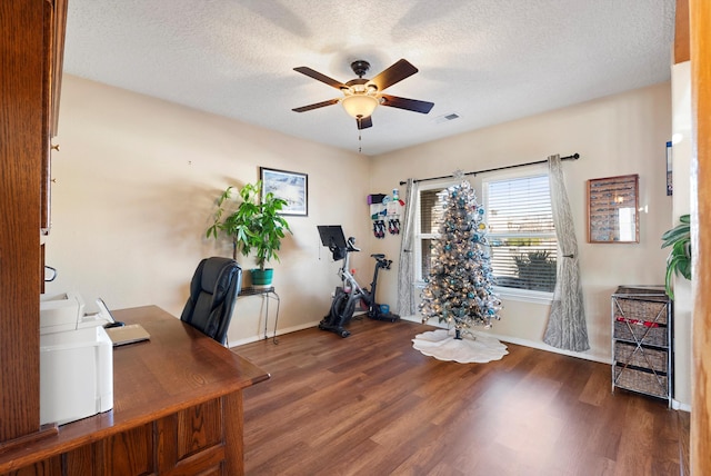 home office with baseboards, a textured ceiling, ceiling fan, visible vents, and wood finished floors