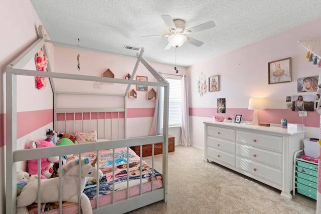 carpeted bedroom with a ceiling fan, visible vents, and a textured ceiling