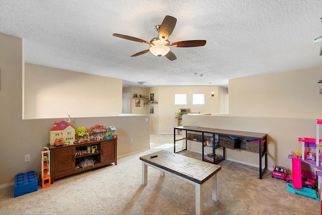 game room featuring a textured ceiling, carpet flooring, a ceiling fan, and baseboards