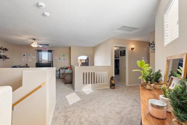 interior space featuring a ceiling fan, baseboards, attic access, and a textured ceiling