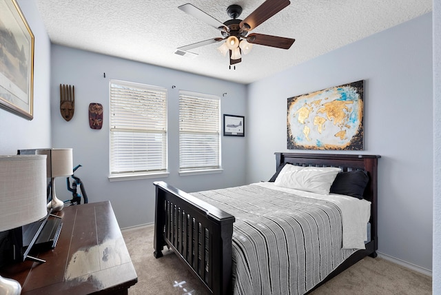 carpeted bedroom with a textured ceiling, a ceiling fan, and baseboards